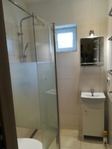 Badewanne zur Dusche umbauen in Wien: Fertiges Badezimmer mit Glasduschwand und Waschtisch