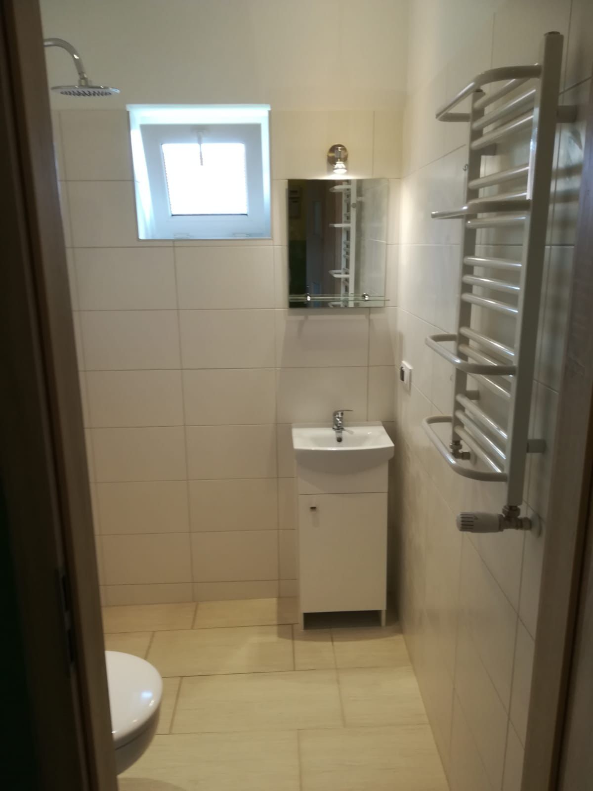 Helles kompaktes Badezimmer mit Handtuchheizkörper und Waschtisch nach Umbau