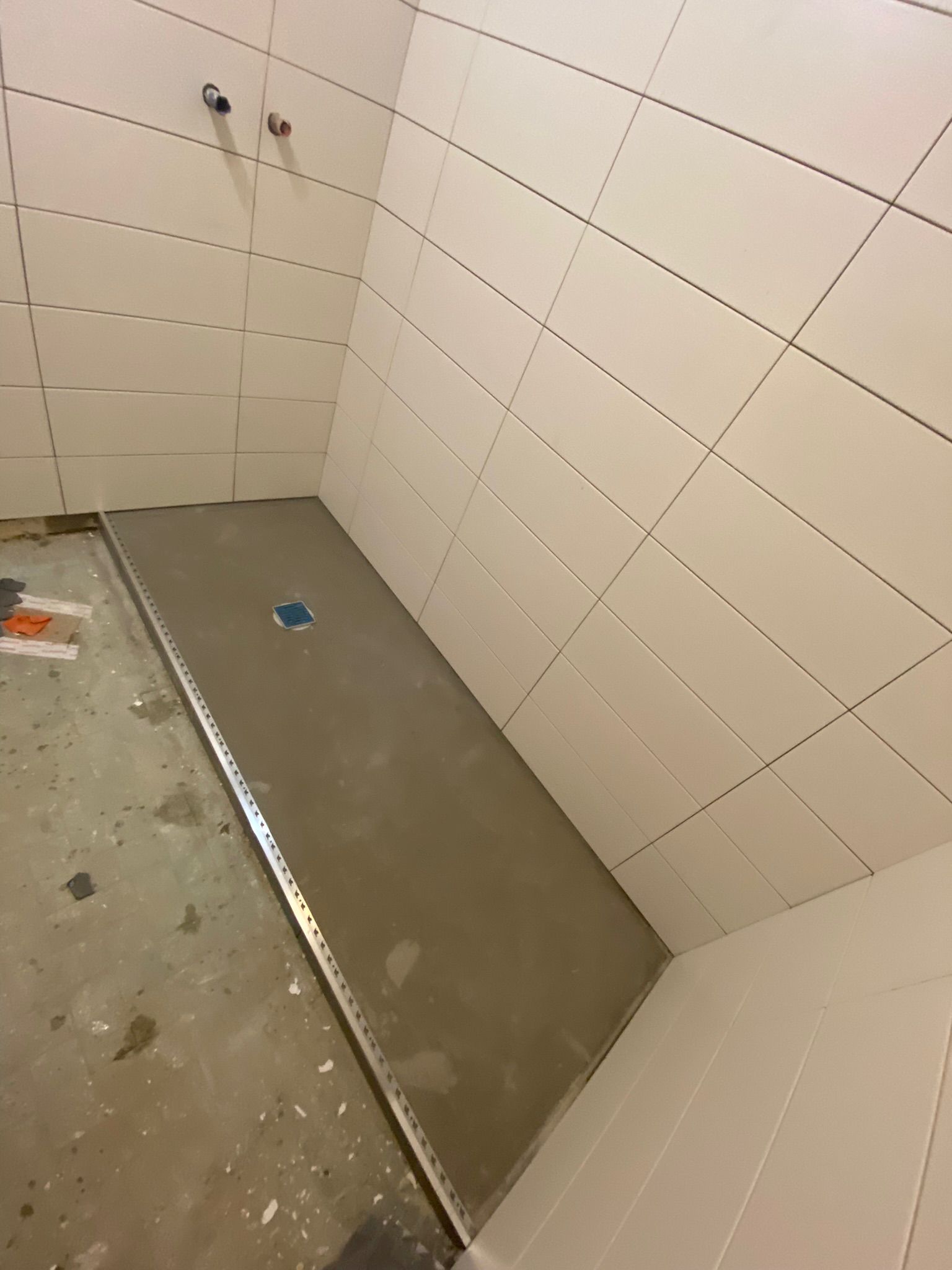 Helle Wandfliesen verlegen in begehbarer Dusche 1200 Wien